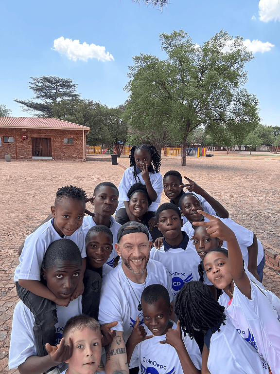 Children and volunteers taking a group selfie