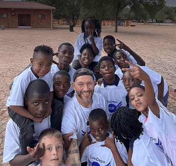 Children and a volunteer posing together